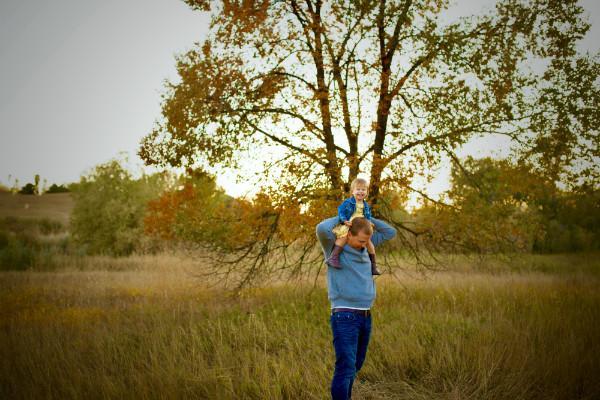 A child riding on their father's shoulders | children's dentistry Greeley CO