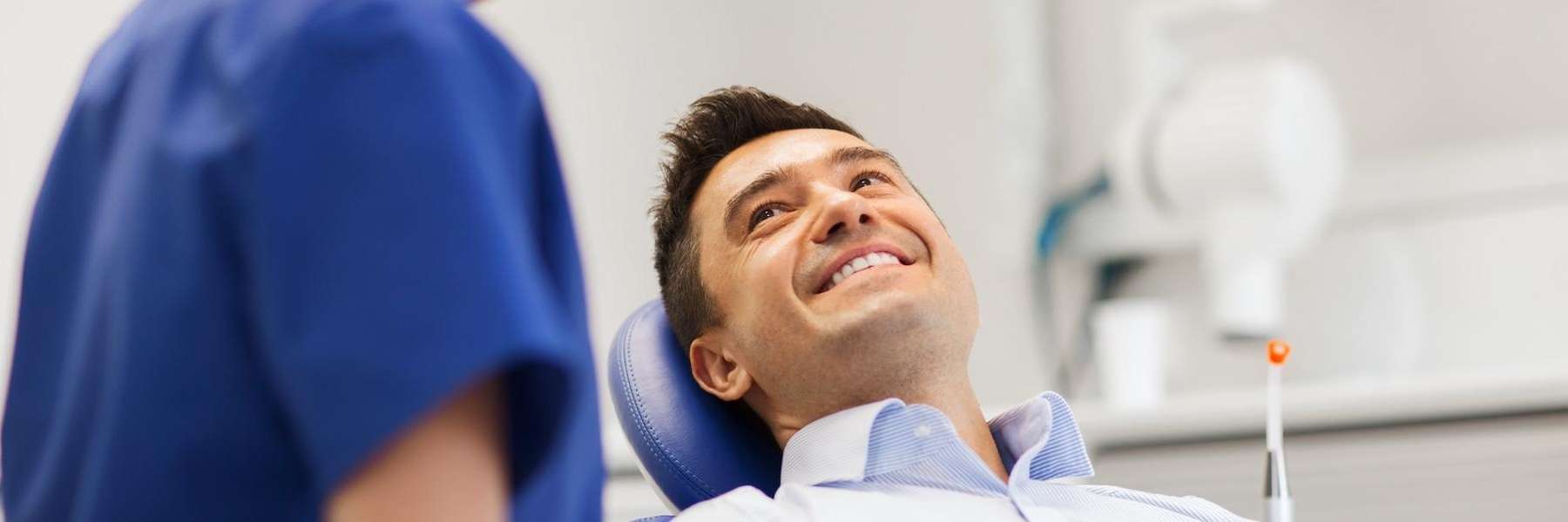 A smiling man getting a dental exam in Greeley
