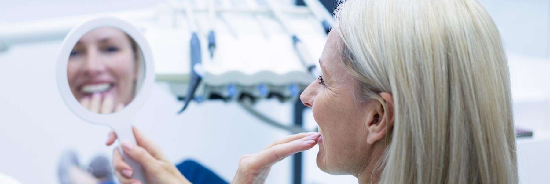A woman at the dentist looking at her new dental crowns
