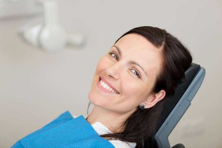 A smiling woman getting a dental exam