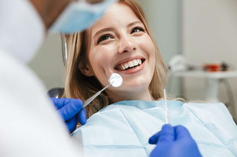 A smiling woman getting a dental exam
