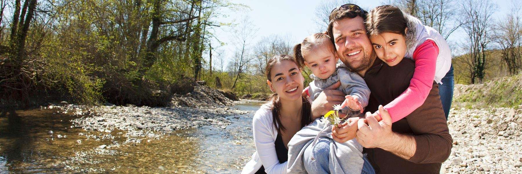 A smiling family posing by the river | dentist 80634